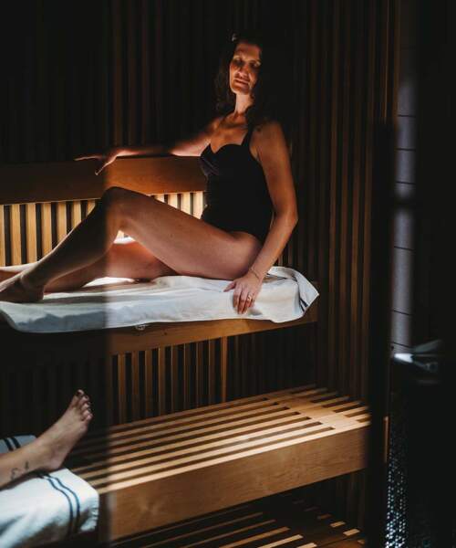 2 women sitting inside Tylo Reflection RIB 3 tiered sauna