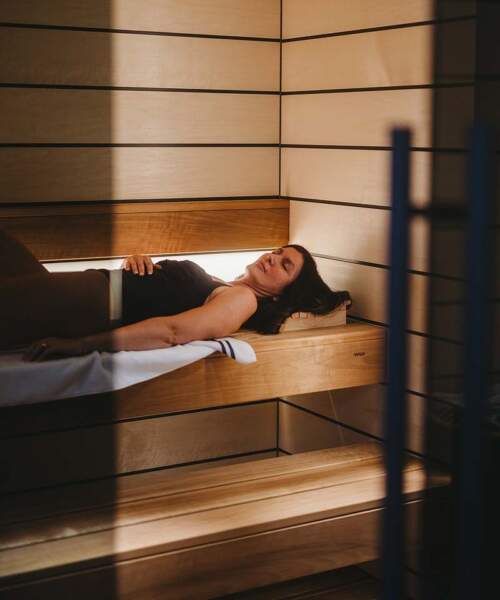 Woman lying inside Tylo Reflection Sauna GC WIDE